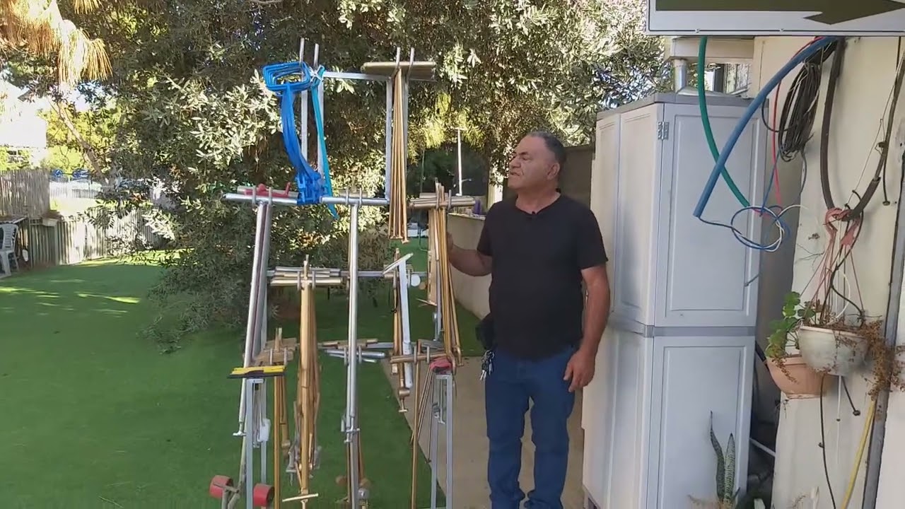 ציון שירי לצד מכשירים ומפתחות שייצר לפתיחת מכסים